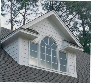Closeup view of roofing with white color siding and windows