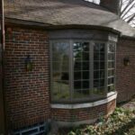 bay windows installed on front of brick suburban home